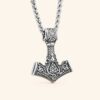 detalle-colgante-mjolnir-vikingo-valknut-acero-316l Colgante Mjolnir de Thor con Valknut en acero inoxidable 316L sobre fondo claro minimalista